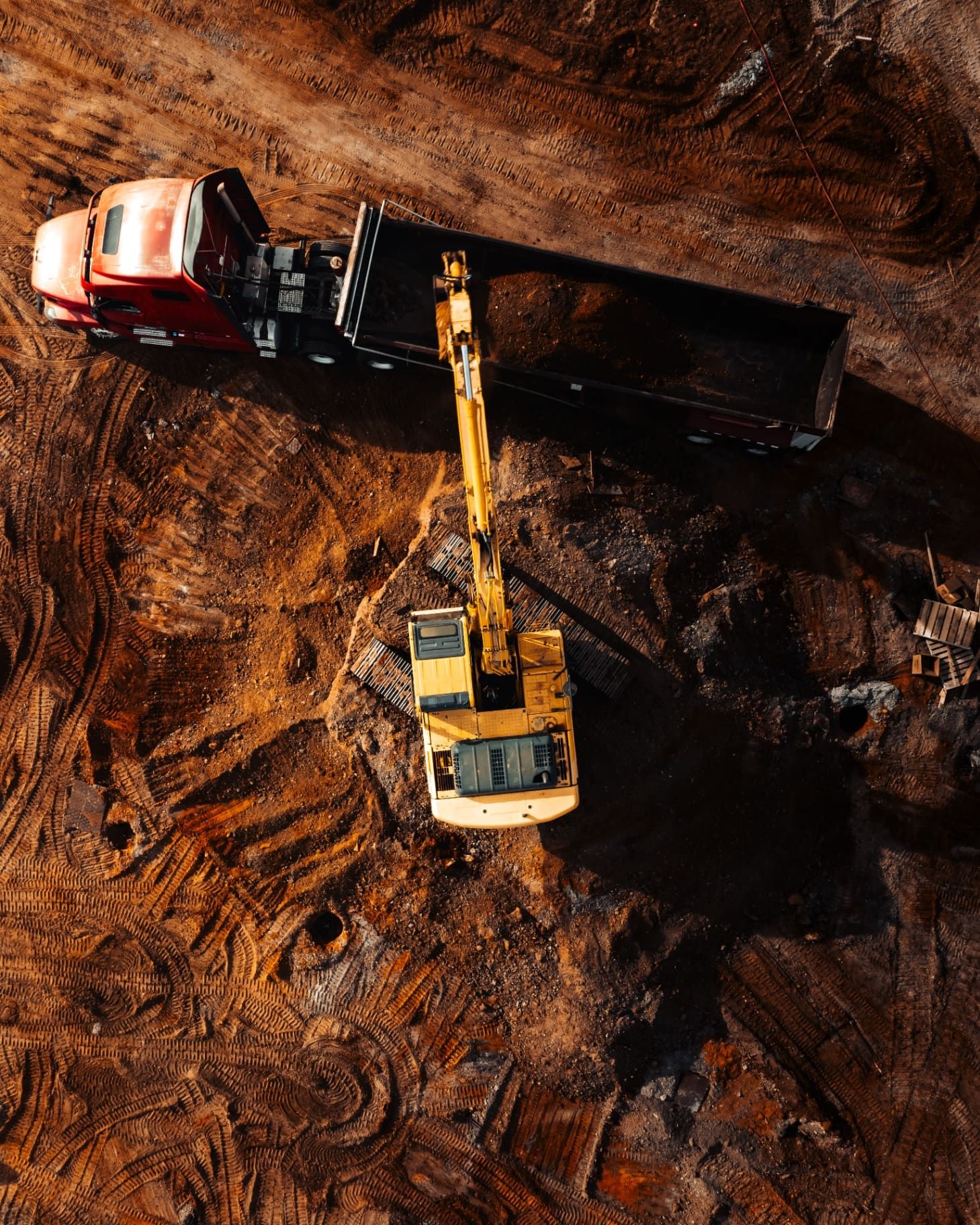 Aerial view of excavator loading truck on site