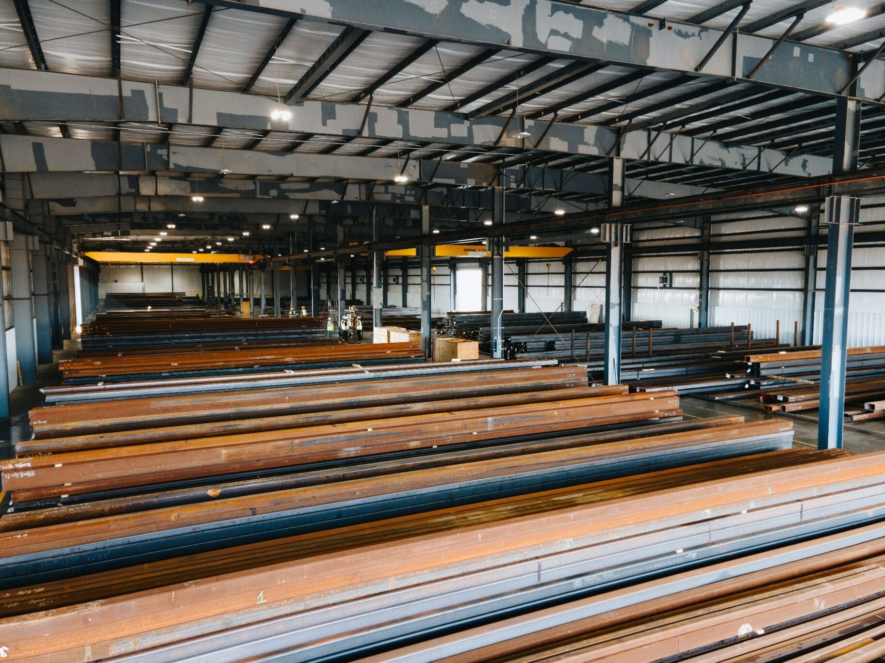 Elevated interior view of the Brown Strauss warehouse with rows of steel beams and overhead cranes