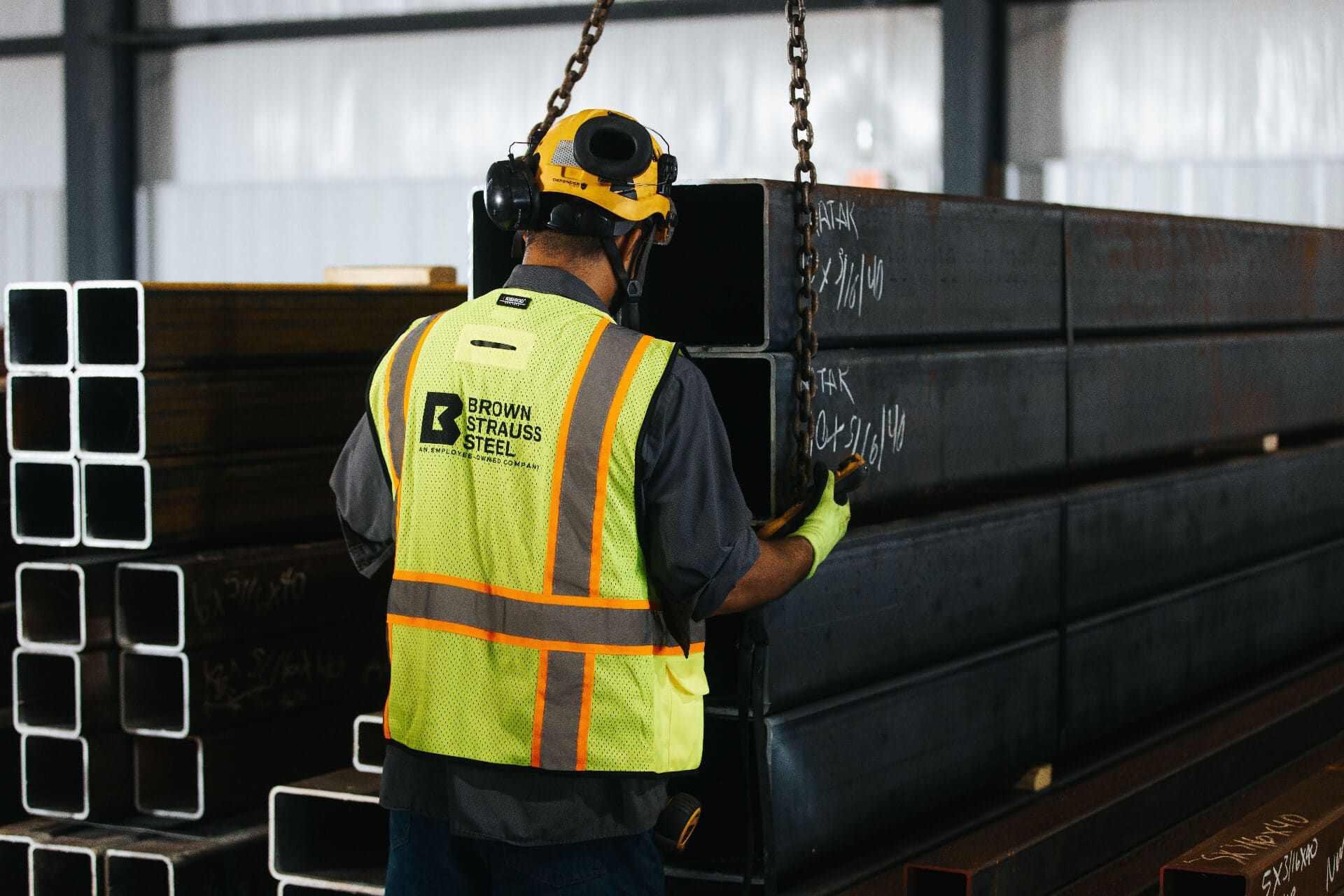 Brown Strauss Steel worker moving tube steel in the Houston facility