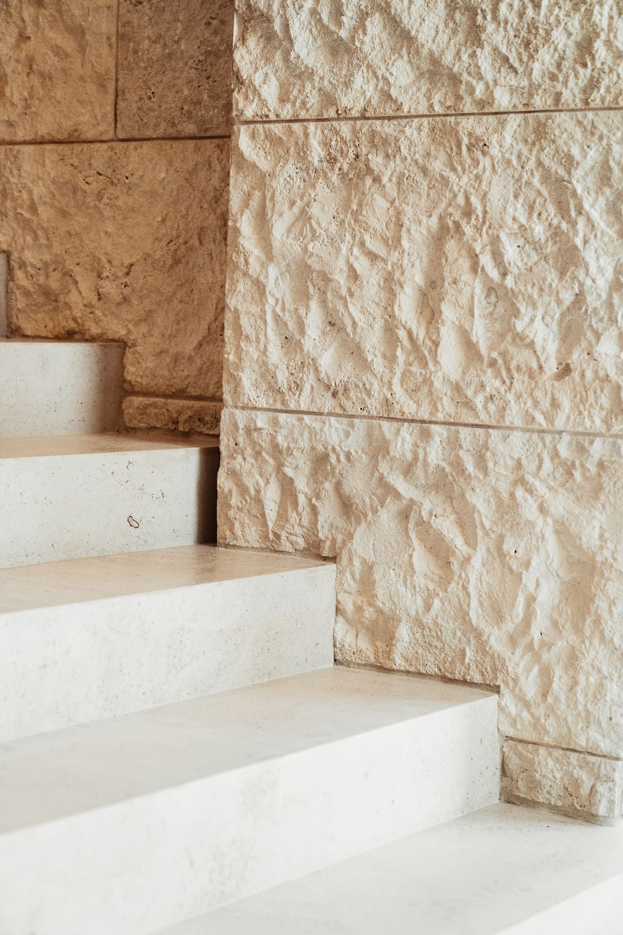Limestone stairs with textured stone wall